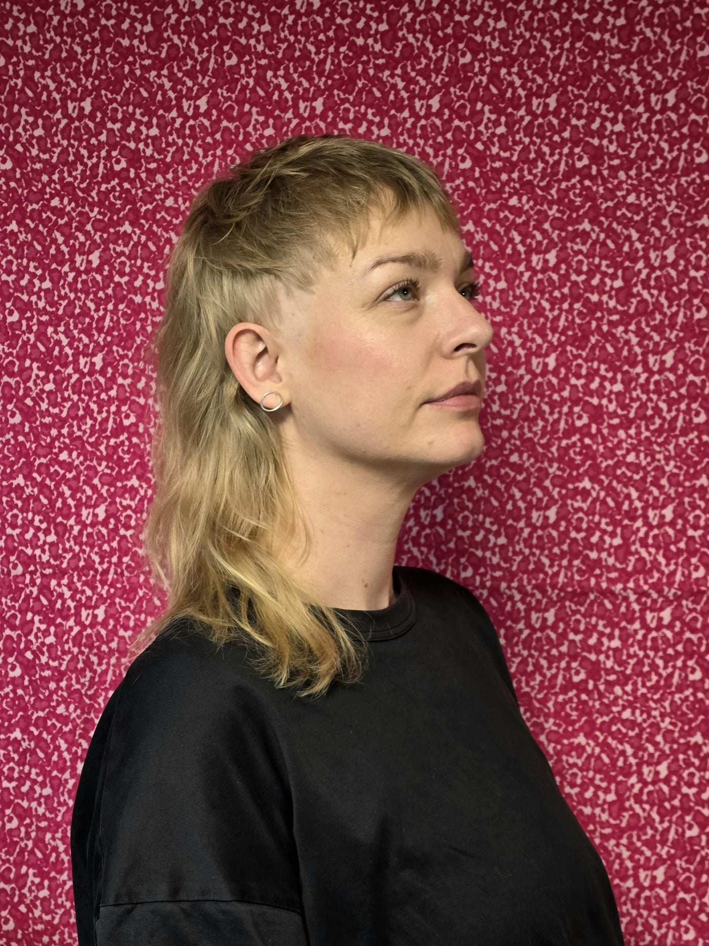 Blonde mullet, pink wall